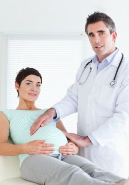 Portrait of a male doctor and a pregnant woman clipart