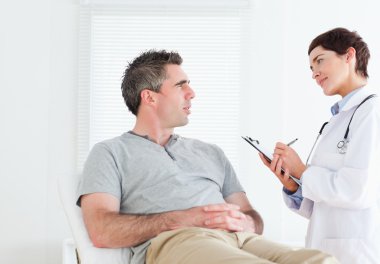 Female doctor talking to a patient clipart