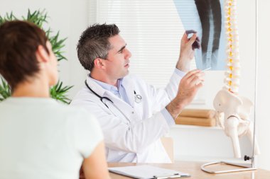 Male Doctor showing a female patient a x-ray clipart