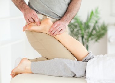 Masseur massaging a female customer's foot clipart