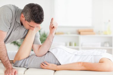 Chiropractor stretches customer's leg clipart