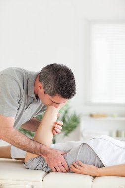 Customer's leg stretched by chiropractor clipart