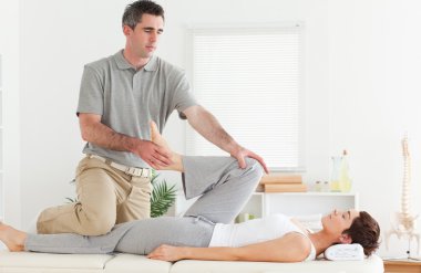 Chiropractor stretching customer's leg clipart