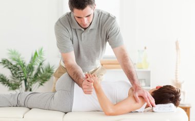 Masseur stretching woman's arm clipart