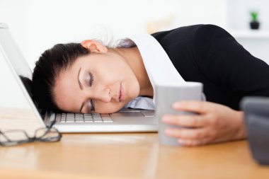 Exhausted businesswoman sleeping at workplace clipart