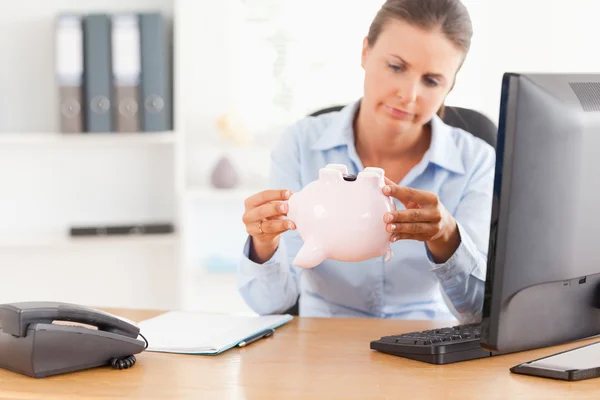 Office worker with an empty piggy bank — Stock Photo, Image