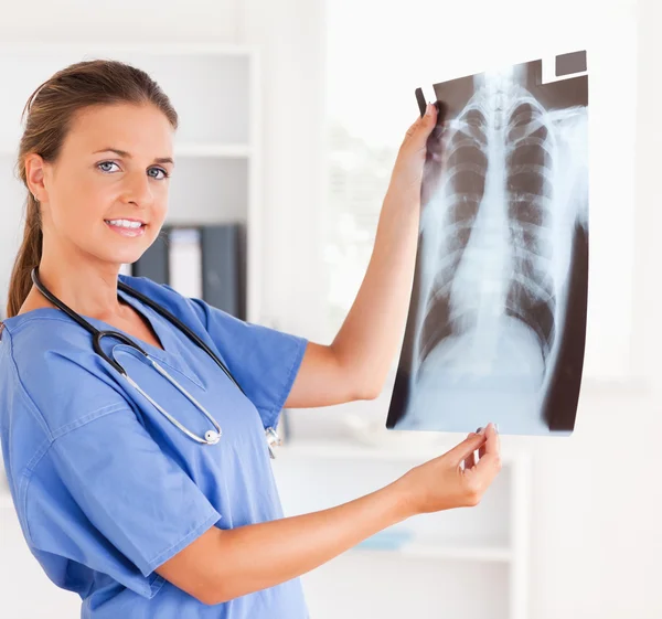 Arzt mit Stethoskop und Röntgenbild blickt in Kamera — Stockfoto
