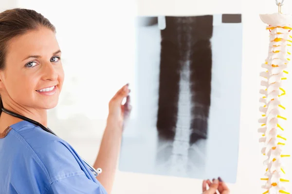 Morena sorrindo médico com um estetoscópio e um raio-x — Fotografia de Stock
