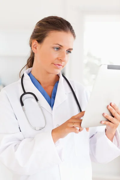 Charmiga läkare med stetoskop pekar på en fil — Stockfoto