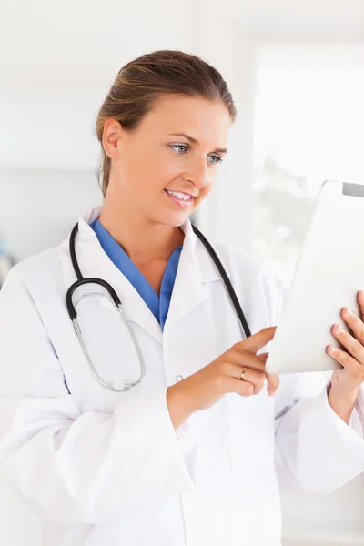 Bir dosyaya işaret eden bir stetoskop ile doktor gülümseyen — Stok fotoğraf