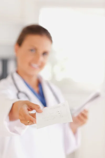 Sorrindo morena médico distribuindo uma receita — Fotografia de Stock