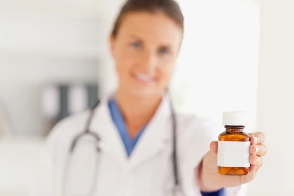 Médico bonito entregando alguns comprimidos — Fotografia de Stock