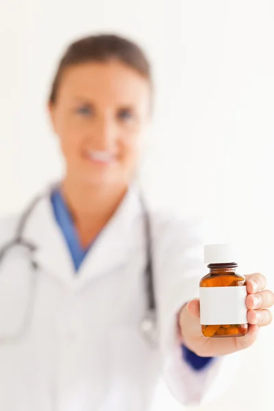 Nahaufnahme eines niedlichen Arztes, der ein paar Tabletten verteilt — Stockfoto