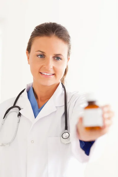 Porträt eines niedlichen Arztes, der ein paar Tabletten verteilt — Stockfoto