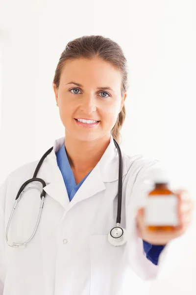 Retrato de um médico encantador entregando algumas pílulas — Fotografia de Stock