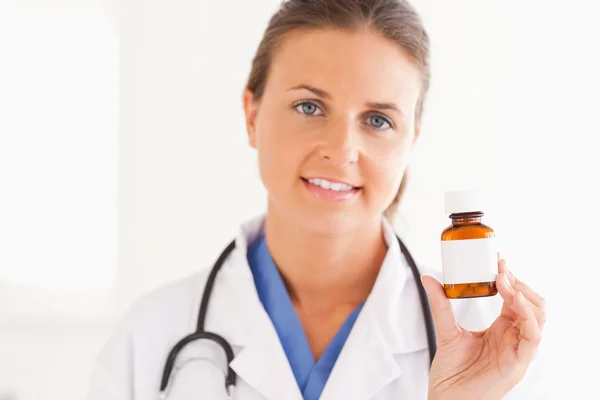 Retrato de un médico sonriente sosteniendo unas pastillas — Foto de Stock