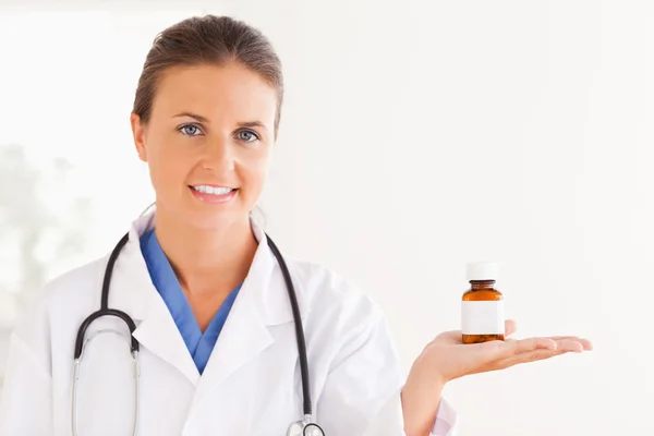 Retrato de um médico morena olhando para algumas pílulas — Fotografia de Stock