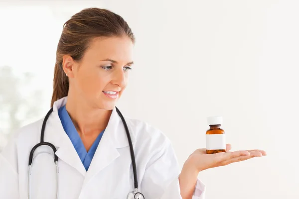 Симпатичный доктор смотрит на таблетки. — стоковое фото