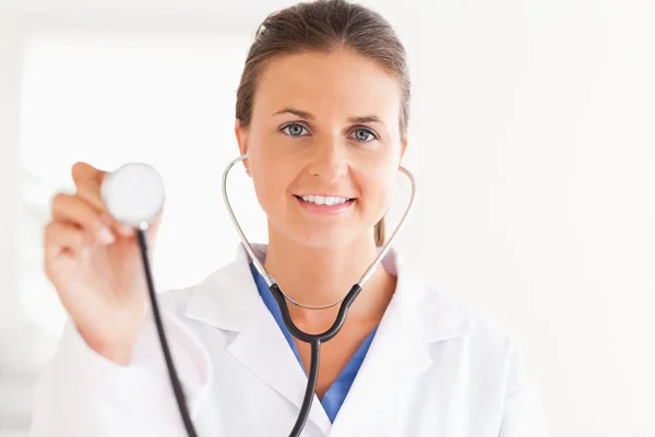 Prachtige brunette arts weergegeven: stethoscoop op zoek naar de certificeringsinstantie — Stockfoto