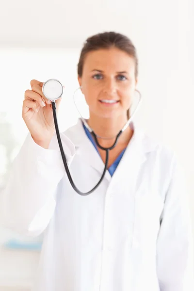 Usmívající se doktor ukazující stetoskop do fotoaparátu — Stock fotografie