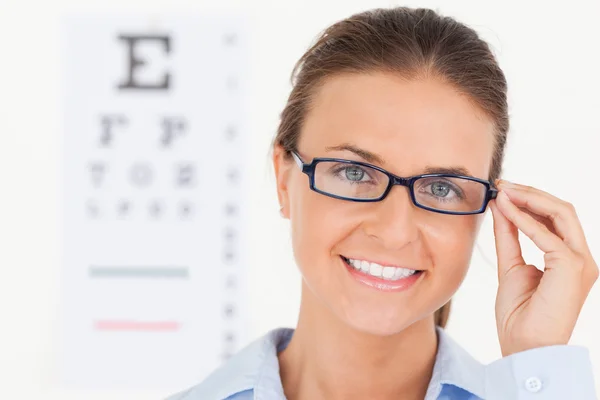 Nahaufnahme einer gut aussehenden brünetten Augenärztin mit Glas — Stockfoto