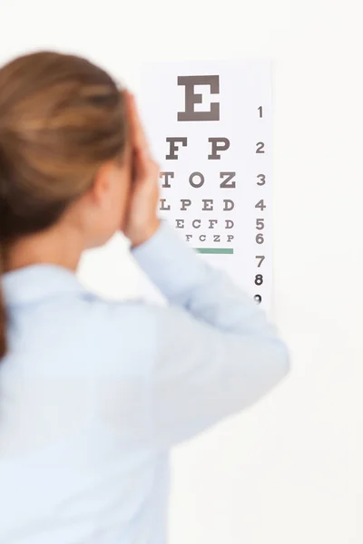 Женщина смотрит на тест на зрение — стоковое фото