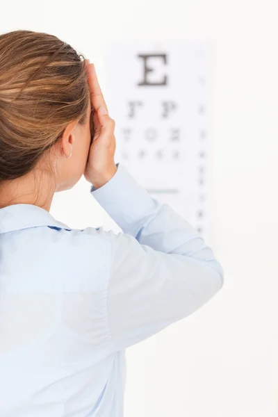 Брюнетка смотрит на тест на зрение — стоковое фото