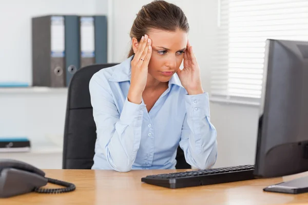 Стрессовая женщина сидит в офисе — стоковое фото