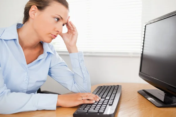 Женщина, которая ищет компьютерный экран в офисе — стоковое фото