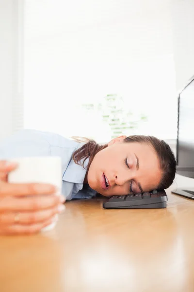 Empresária dormindo segurando café no escritório — Fotografia de Stock