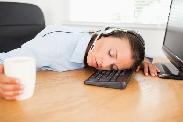 Mujer de negocios con auriculares durmiendo en la oficina — Foto de Stock