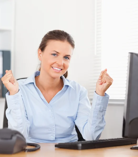 Szczęśliwa kobieta siedzi w biurze — Zdjęcie stockowe