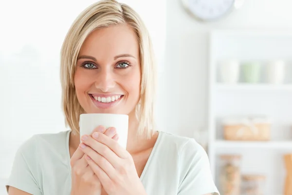 Close up of a woman taking in smell of coffee looking into the c — Stock Photo, Image