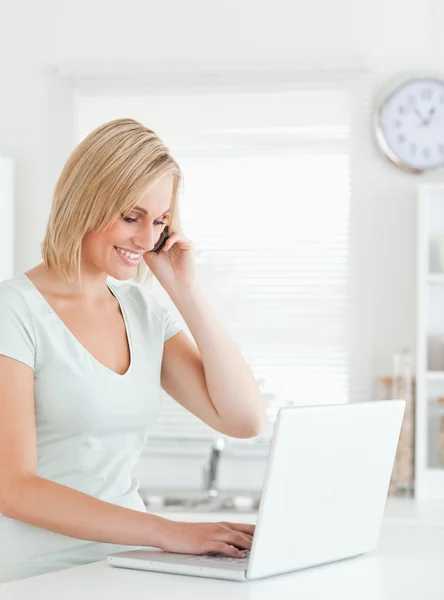 Blond kvinna med en bärbar dator och en telefon — Stockfoto