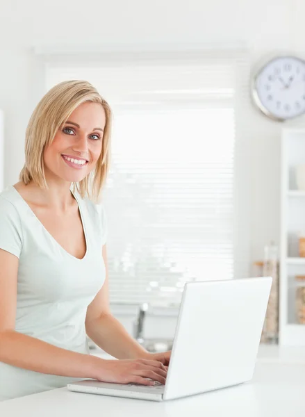 Kameraya bakarak bir dizüstü bilgisayar ile sarışın kadın — Stok fotoğraf