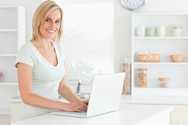 Charming woman with a laptop looking into the camera — Stock Photo, Image