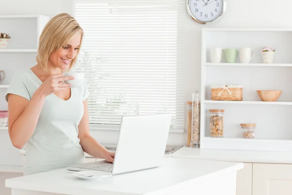 Bir fincan kahve ve bir dizüstü bilgisayar ile kadın — Stok fotoğraf
