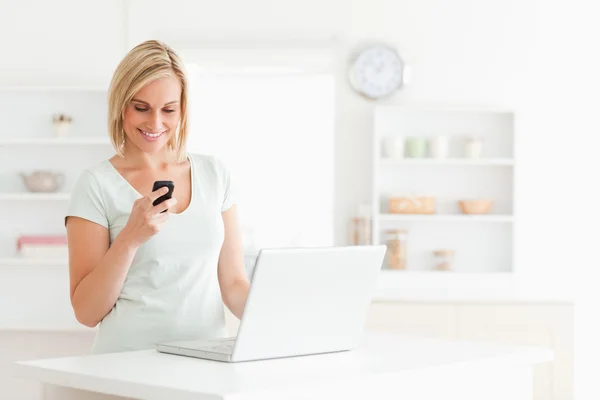 Mulher bonito com um celular e um laptop — Fotografia de Stock