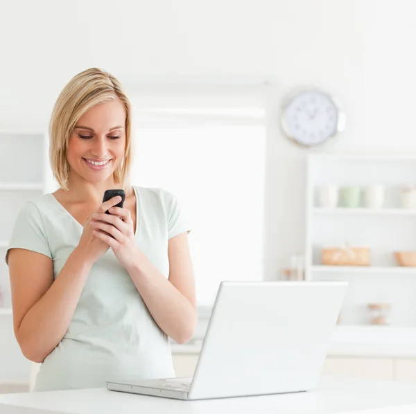 Cute woman with mobile and laptop smiling — Stock Photo, Image
