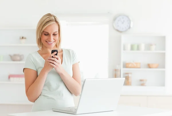 Söt kvinna ler mot sin mobil — Stockfoto