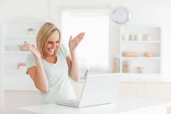 Смеющаяся женщина смотрит на ноутбук — стоковое фото