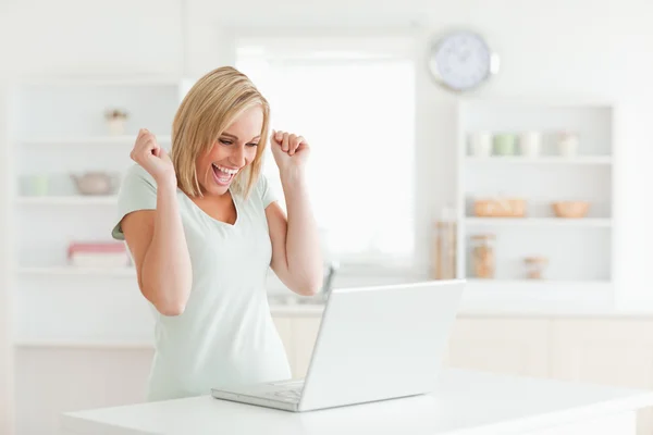 Skrattar blonda kvinnan tittar på laptop — Stockfoto