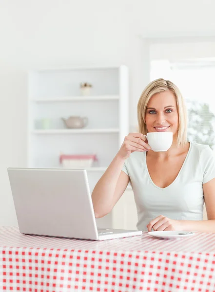 Mulher bebendo café com caderno na frente dela — Fotografia de Stock