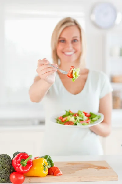Junge Frau bietet Salat an — Stockfoto