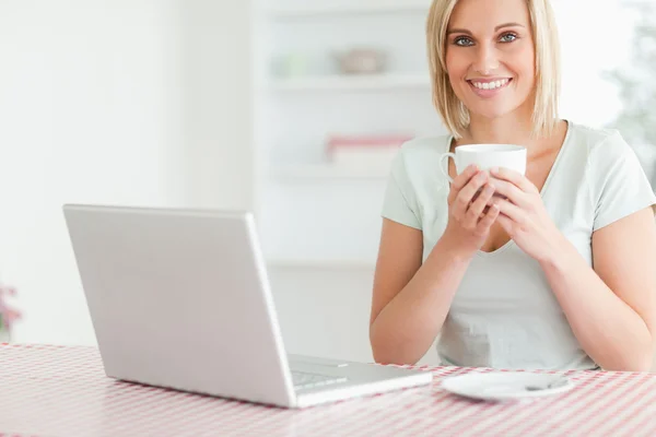 Närbild på en kvinna med kaffe med laptop framför hennes l — Stockfoto