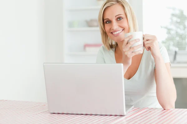 Närbild på en kvinna med kaffe med laptop framför hennes s — Stockfoto