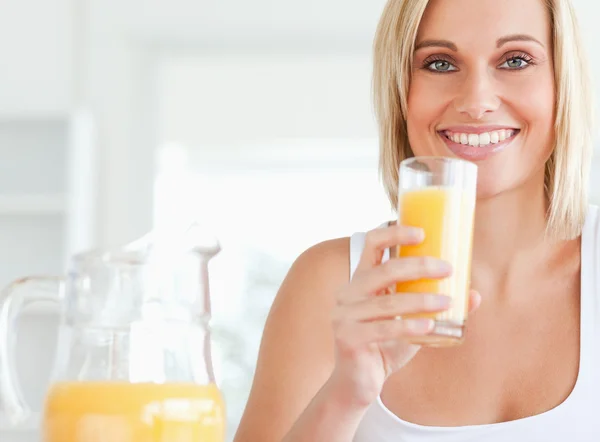 Kvinna som dricker apelsinjuice — Stockfoto