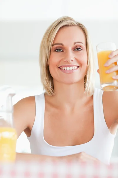 Smiling woman toasting with orange juice — Stock Photo, Image