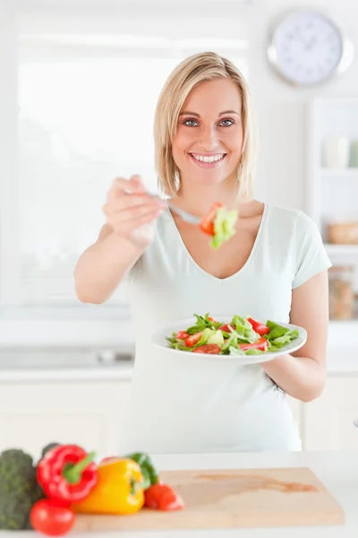 Lächelnde Frau bietet Salat an — Stockfoto