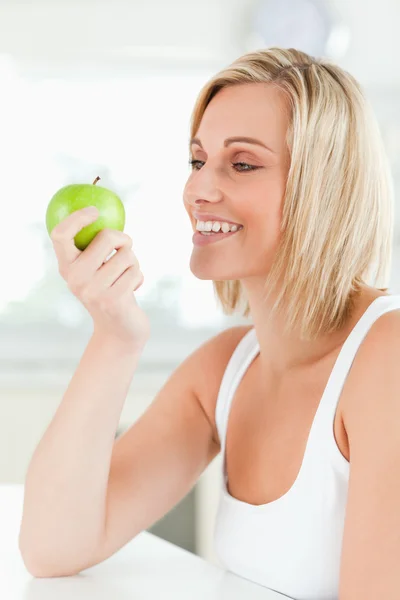 Jovem sorrindo mulher assistindo uma maçã verde — Fotografia de Stock